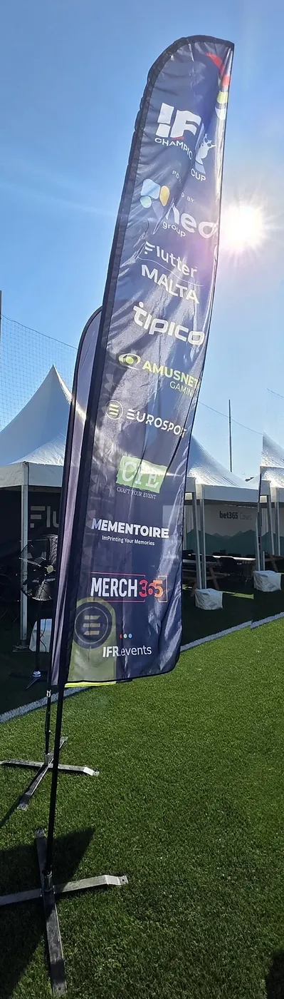 Sponsor feather flag at the IFR Champions Cup, featuring Mementoire and Merch365
